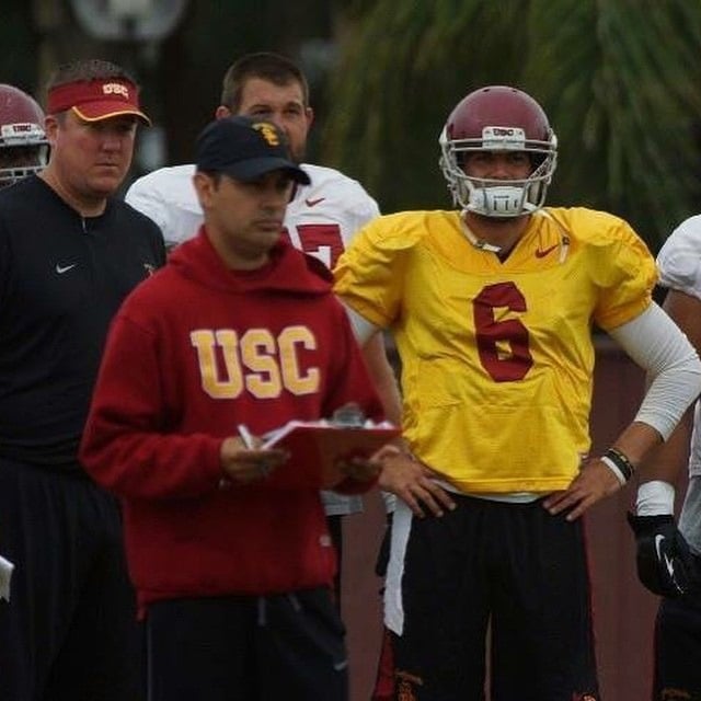 Coach Bass coaching a young quarterback on footwork and arm mechanics